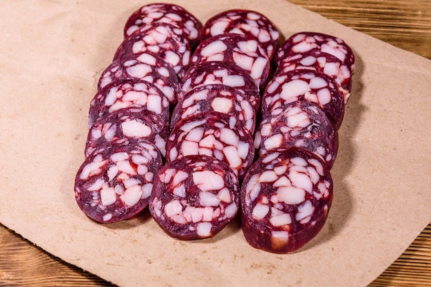 Salchicha de salami en rodajas en un papel de regalo marrón