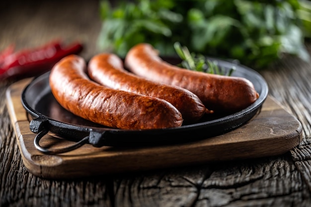 Salchichas ahumadas de cerdo con pimienta y romero en una sartén de hierro fundido