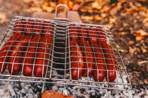 Salchichas al fuego en una barbacoa portátil