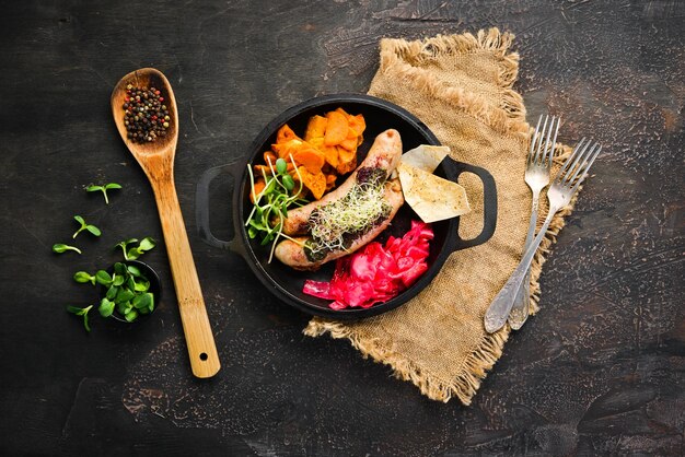 Salchichas al horno batatas y repollo En el plato Vista superior Espacio libre para su texto Estilo rústico