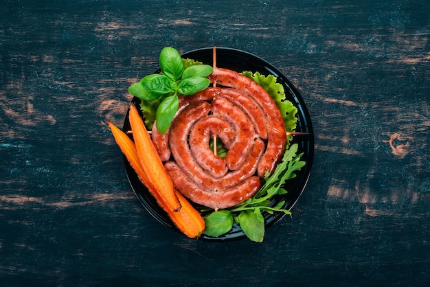 Salchichas asadas fritas con verduras frescas Sobre un fondo de madera Vista superior Espacio de copia