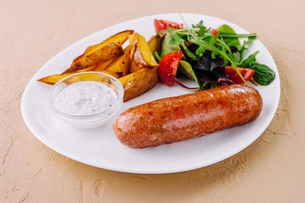 Salchichas asadas con patatas al horno y ensalada verde