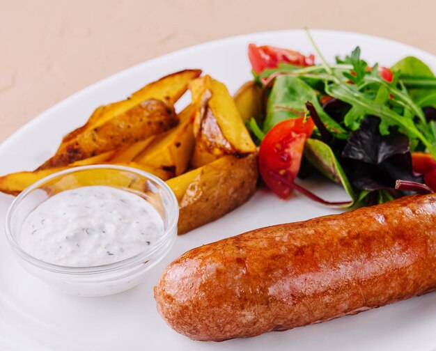 Salchichas asadas con patatas al horno y ensalada verde