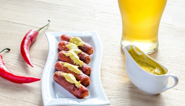 Salchichas asadas con vaso de cerveza