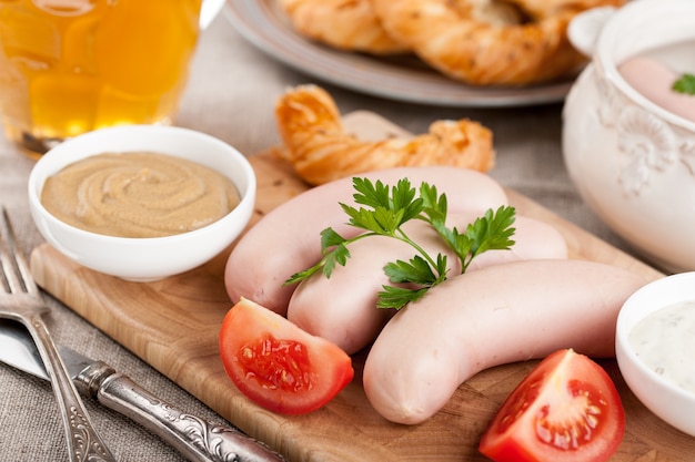 Salchichas blancas cocidas con cerveza y pretzel