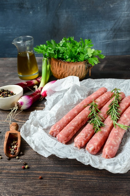 Salchichas de carne cruda para barbacoa o hot dog. cebolla morada, sal y pimienta, orégano fresco para marinar. parrillada cena familiar