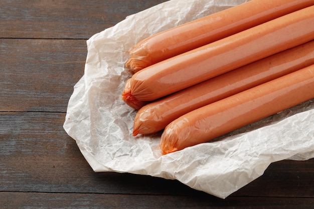 Salchichas de carne fresca en mesa de madera marrón