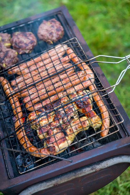 Salchichas de carne de pollo y hamburguesas a la parrilla al aire libre