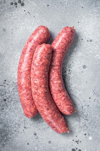 Salchichas de carne de res cruda listas para cocinar Fondo gris Vista superior