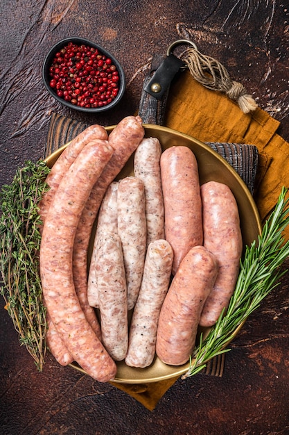 Salchichas caseras crudas variadas con cordero de cerdo y carne de pollo en un plato Fondo oscuro Vista superior