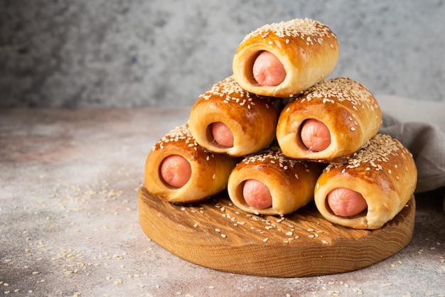 Salchichas caseras en masa sobre una tabla de madera, comida rápida