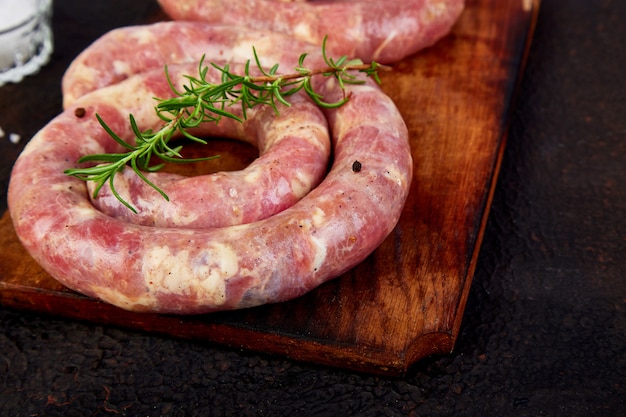 Salchichas de cerdo crudas en espiral con romero, sal y pimienta