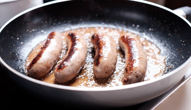 Salchichas cocinando en sartén