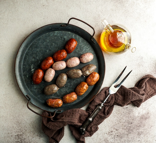 Salchichas españolas en la tabla de cortar - butifarra blanca, chorizo, morcilla de cebolla