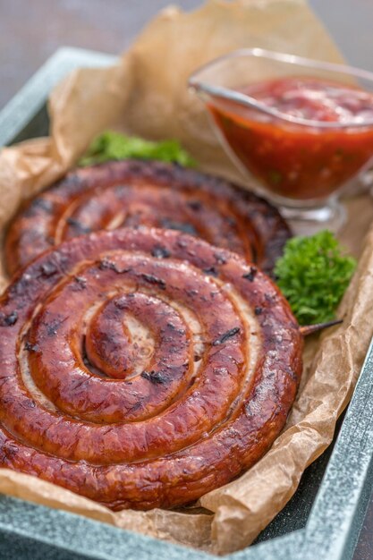 Salchichas espirales ahumadas a la parrilla con salsa de tomate al aire libre