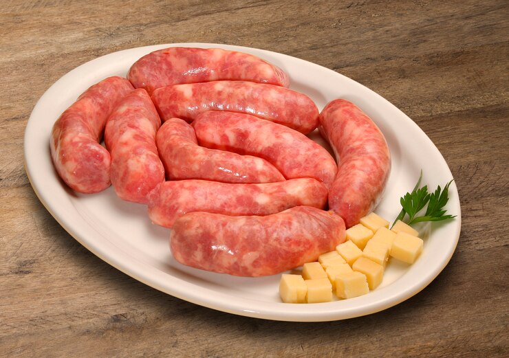 Salchichas frescas y crudas sobre el viejo fondo de madera.