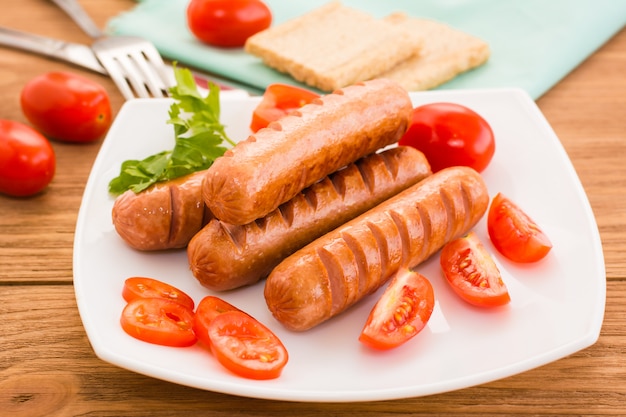 Salchichas fritas y tomates en un plato