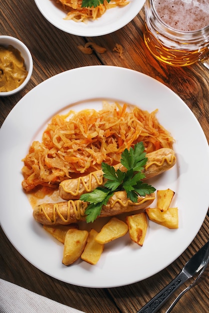 Salchichas de Munich al horno con repollo guisado y un vaso de cerveza