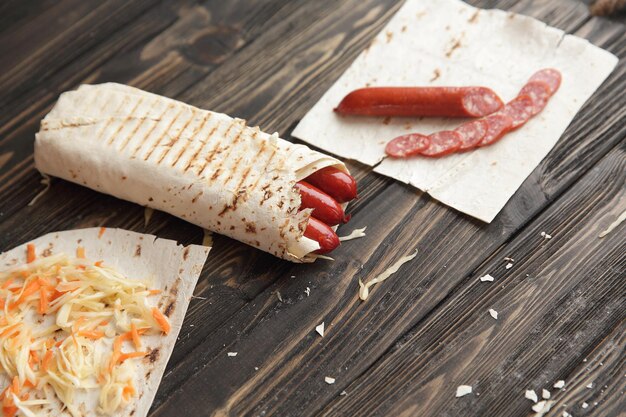 Salchichas en pan de pita sobre fondo de madera