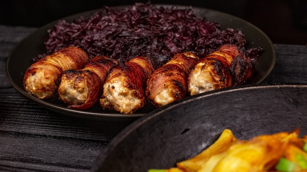 Salchichas a la parrilla caseras fritas o chevapchichi con chucrut guisado sobre un fondo rústico de madera.