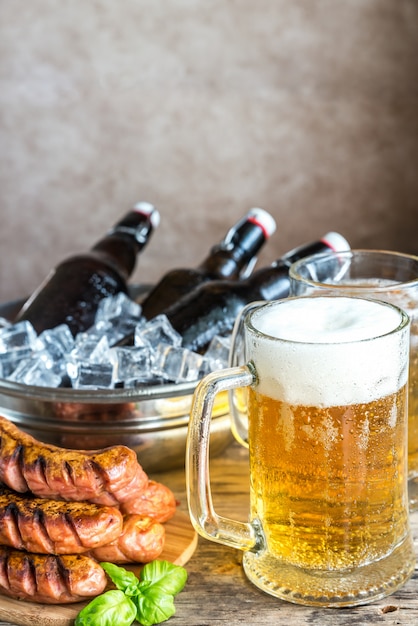 Salchichas a la parrilla y jarras de cerveza