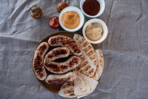 Salchichas a la parrilla con salsa y verduras concepto de descanso de verano