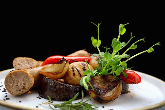 Salchichas a la parrilla, verduras y salsa barbacoa en un plato