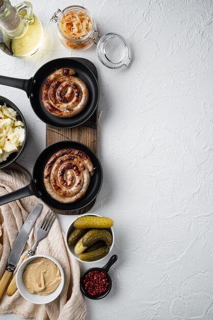 Salchichas tradicionales alemanas con puré de patatas y chucrut en sartén de hierro fundido