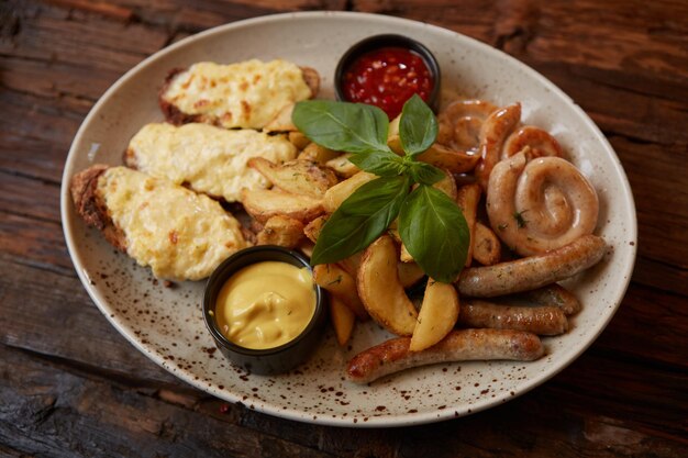 Salchichas variadas a la parrilla con bruschettes de papas fritas con queso y salsas