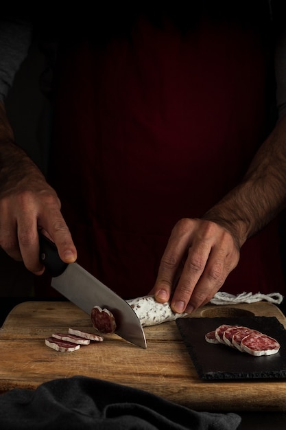 Foto salchichón de corte, estilo de comida oscura, vertical