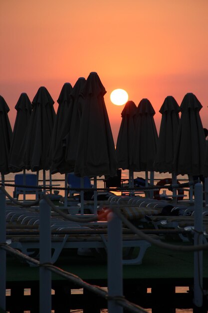 Salida del sol del mar rojo del mar a través de los paraguas