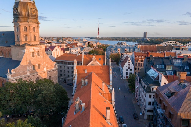 Salida del sol sobre el centro de Riga, Letonia. Vista aérea de la Iglesia de San Pedro. Cerrar vista panorámica de la catedral con el casco antiguo de Riga al fondo.