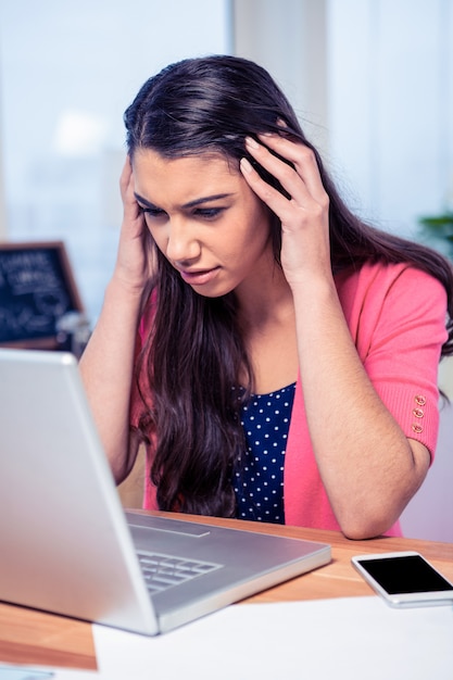 Salientou a linda mulher de negócios com o laptop no escritório criativo