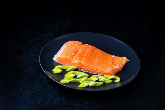 Salmão de peixe salgado com pimenta e cebola em um prato preto Vista superior Espaço livre para o seu texto