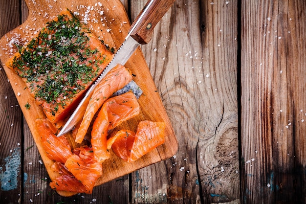 Salmão defumado caseiro com endro em uma mesa de madeira