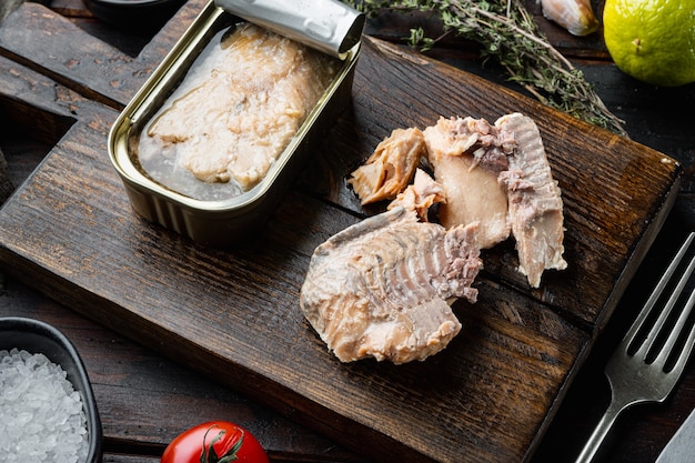 Salmão enlatado, conservas de peixe, na tábua de madeira, na velha mesa de madeira escura