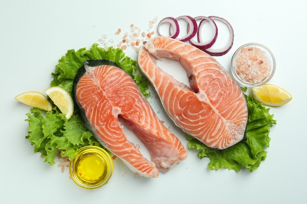 Salmão fresco cru e ingredientes para cozinhar em fundo branco