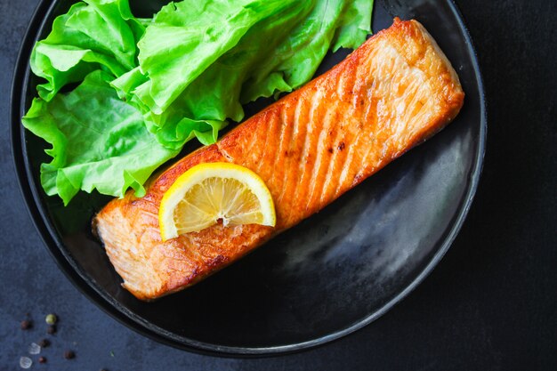 Salmão frito com salada verde em um prato