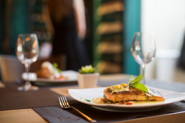 Foto salmão grelhado com molho e ervas servido no restaurante