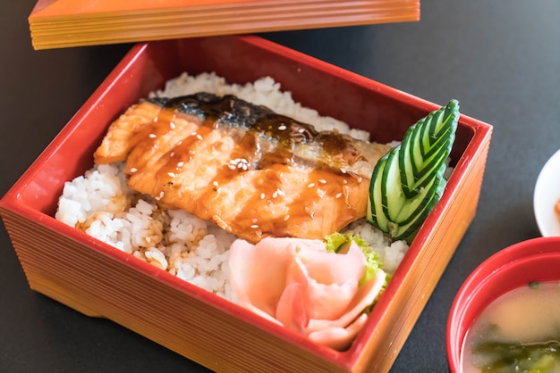 salmão teriyaki em cima de arroz em caixa