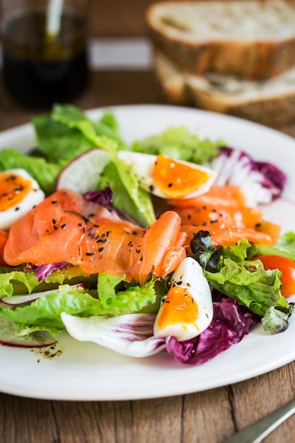 Salmón ahumado con ensalada de huevos cocidos por un poco de pan