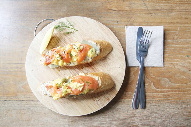 Salmón ahumado y huevos revueltos sobre pan