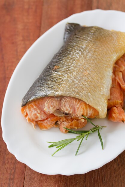 Foto salmón ahumado en plato sobre superficie de madera marrón