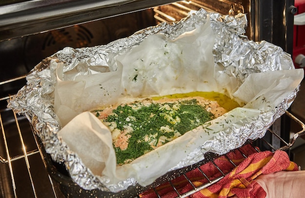 El salmón con ajo y hierbas se hornea en el horno sobre una hoja con papel de aluminio para hornear