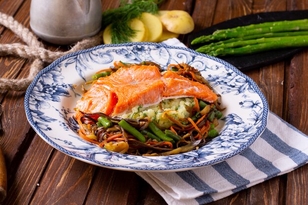 Salmón asado con verduras en la mesa