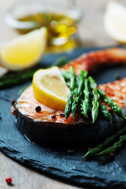 Salmón cocido con espárragos y limón.