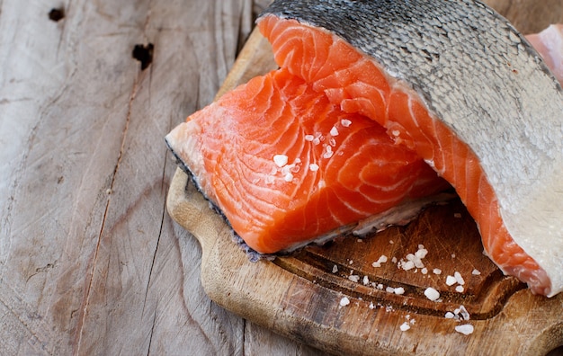 Salmón crudo fresco sobre una tabla de cortar de madera