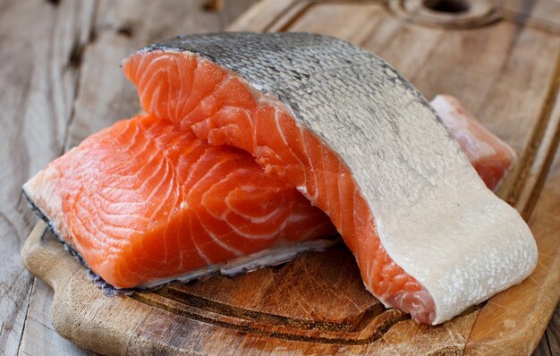 Salmón crudo fresco sobre una tabla de cortar de madera