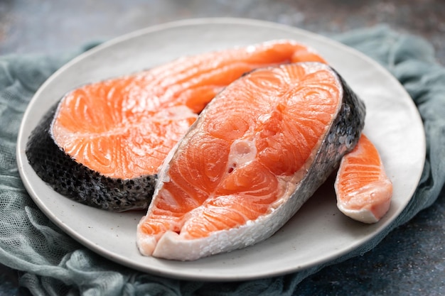 Salmón fresco crudo en plato de cerámica con servilleta en cerámica