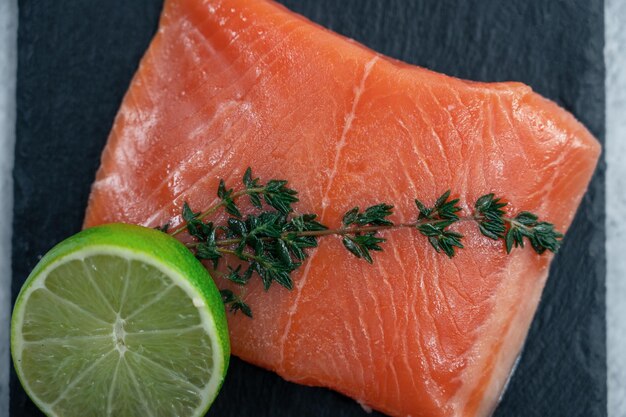 Salmón fresco con verduras y limón sobre fondo de hormigón